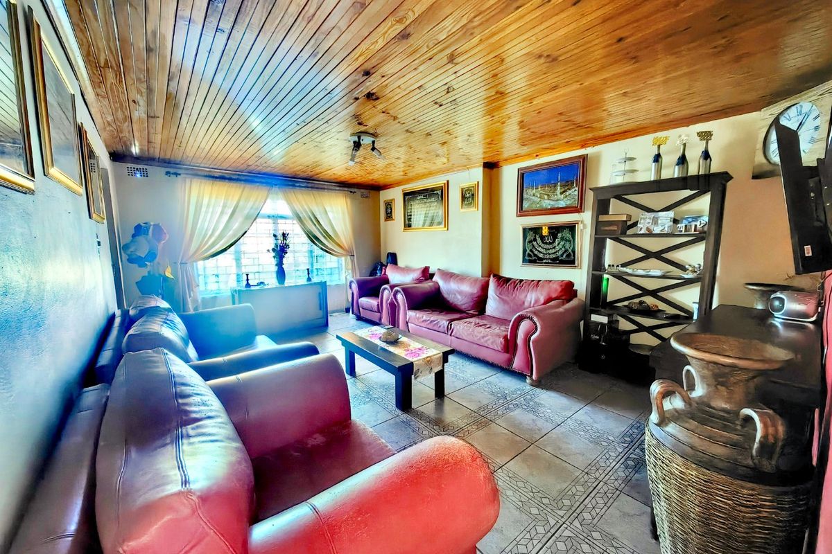 A living room featuring a timber tongue and groove ceiling and ceramic tiled flooring, providing a traditional aesthetic.