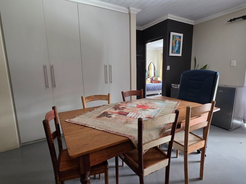 Dining area featuring built-in floor-to-ceiling cupboards, tongue and groove ceiling detailing, and neutral wall finishes.