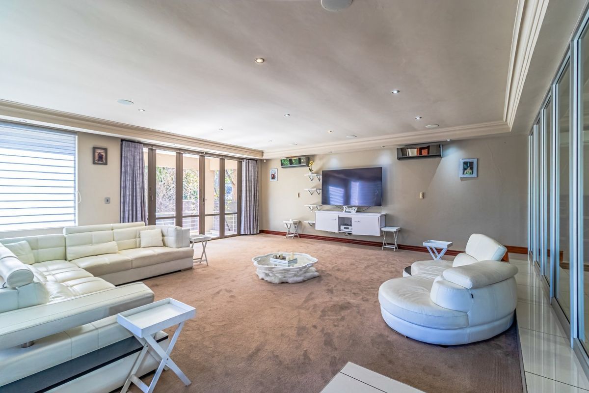 Spacious living room featuring recessed lighting, wall-mounted air conditioning, and large sliding glass doors providing access to the outdoor area.
