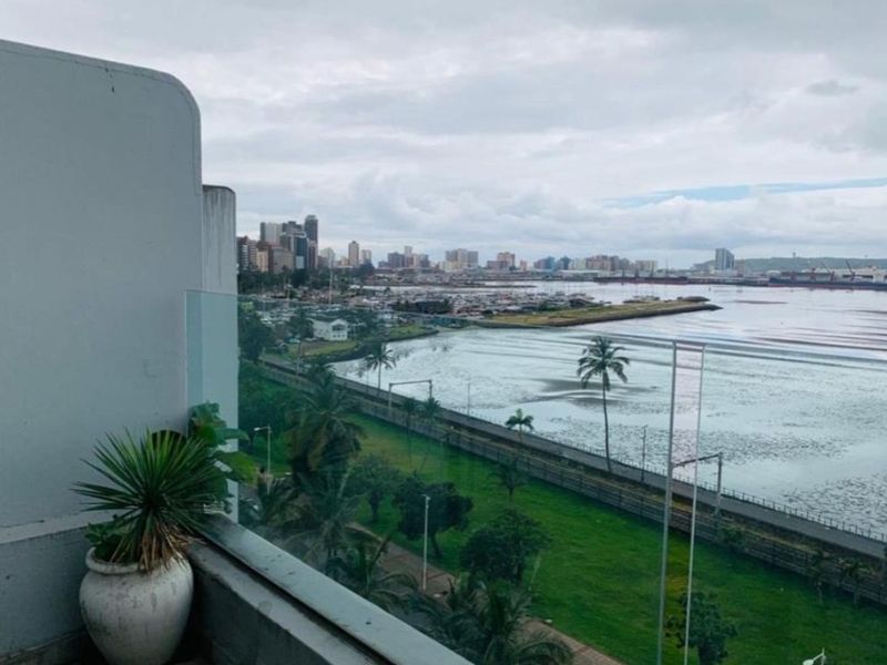 Elevated view overlooking the coastal landscape, harbour, and city skyline from a private balcony.