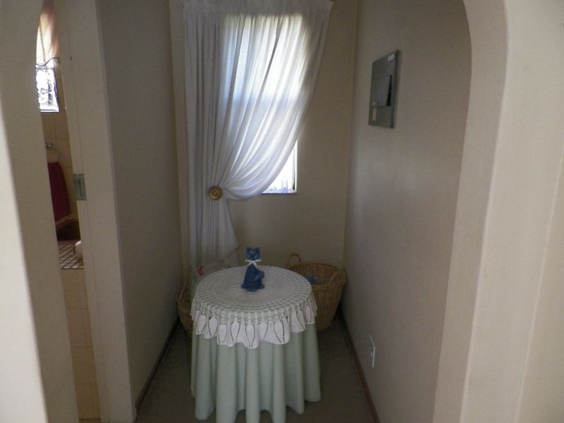 A small hallway or transition space featuring an arched entryway and a wall-mounted electrical distribution board.