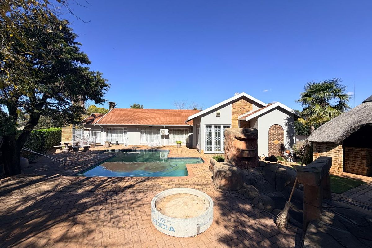 Rear exterior view featuring a swimming pool, paved patio area, and a lapa, set against the back facade of the house.