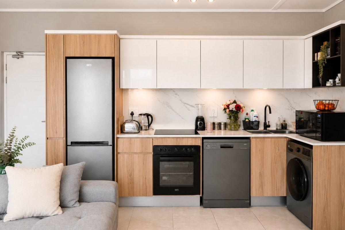 Modern open-plan kitchen featuring sleek wood-grain and white cabinetry, marble-look splashback, integrated appliances, and contemporary track lighting.