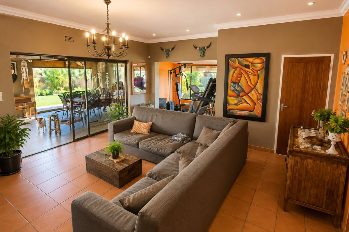 Spacious living room featuring tiled flooring, coved cornicing, and large sliding glass doors that provide seamless access to the outdoor patio area.