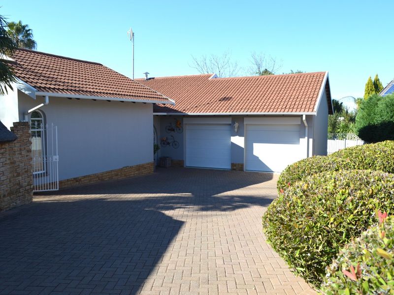 Front view of the property featuring a paved driveway, double garage, and well-maintained exterior finishes.