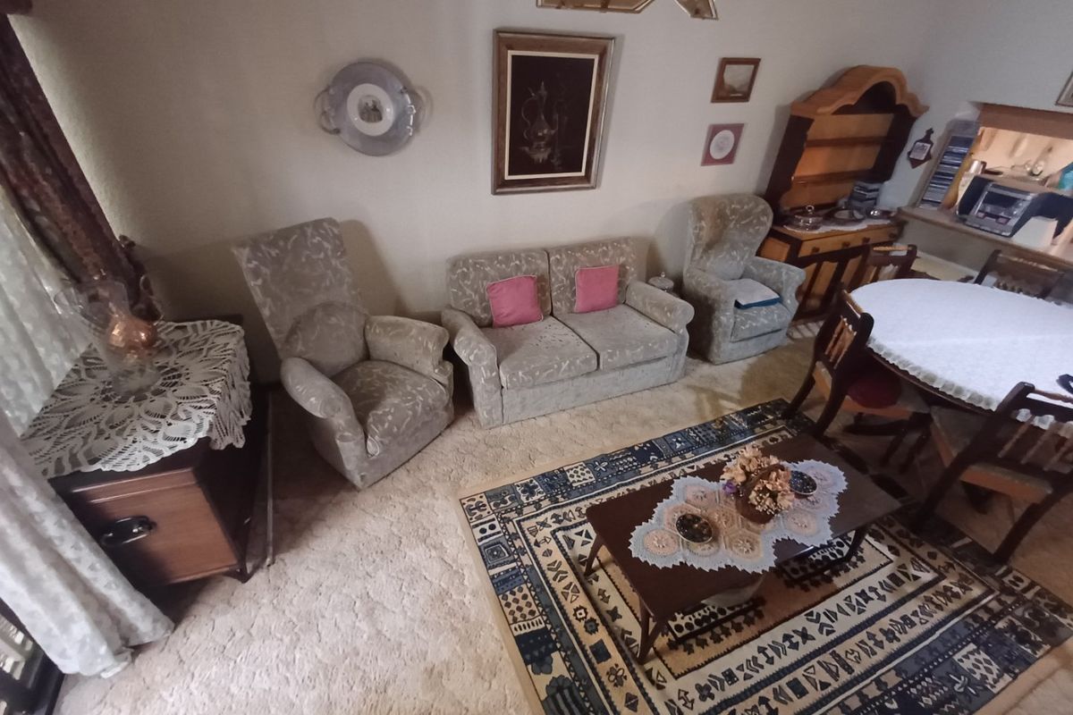 A traditional living room featuring carpeted flooring and built-in cabinetry, offering a comfortable and classic layout for relaxation and dining.
