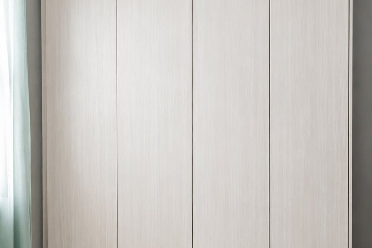 A bedroom featuring a modern, light-wood finish built-in wardrobe with integrated drawers and neutral tiled flooring.