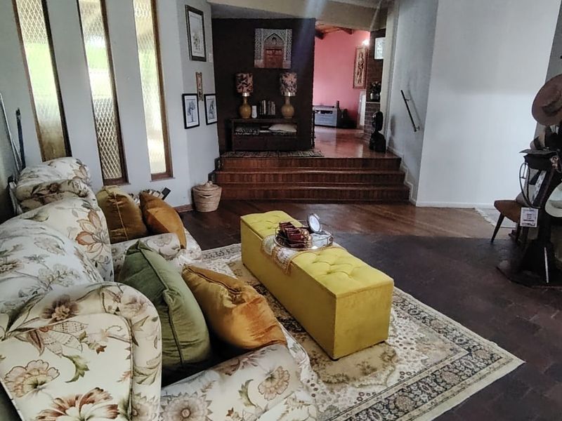Spacious living area featuring hardwood flooring, a raised platform level, and distinctive vertical windows, offering a unique multi-level layout.