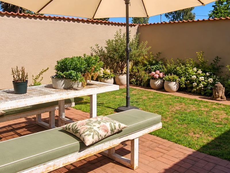 A private outdoor patio area featuring brick paving and a secure boundary wall, providing a pleasant space for outdoor dining and relaxation.
