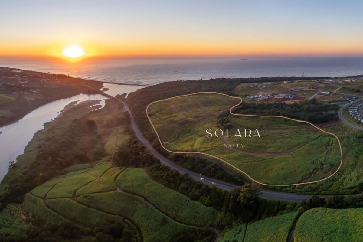 Aerial view of a large, undeveloped residential land parcel featuring scenic river and coastal views at sunset.