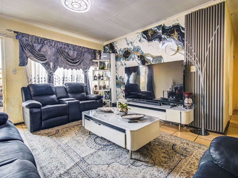 A living room featuring a decorative marble-effect feature wall, vertical slat paneling, and tiled flooring, offering a distinct focal point for the space.