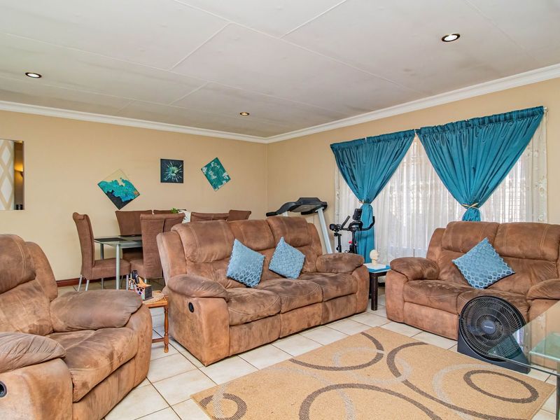 Open-plan living and dining area featuring tiled flooring and recessed downlights, offering a functional space for family gatherings.