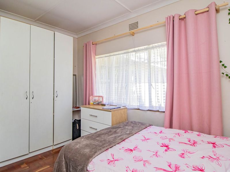 A bedroom featuring timber flooring and a built-in wardrobe, providing functional storage space and a comfortable layout.