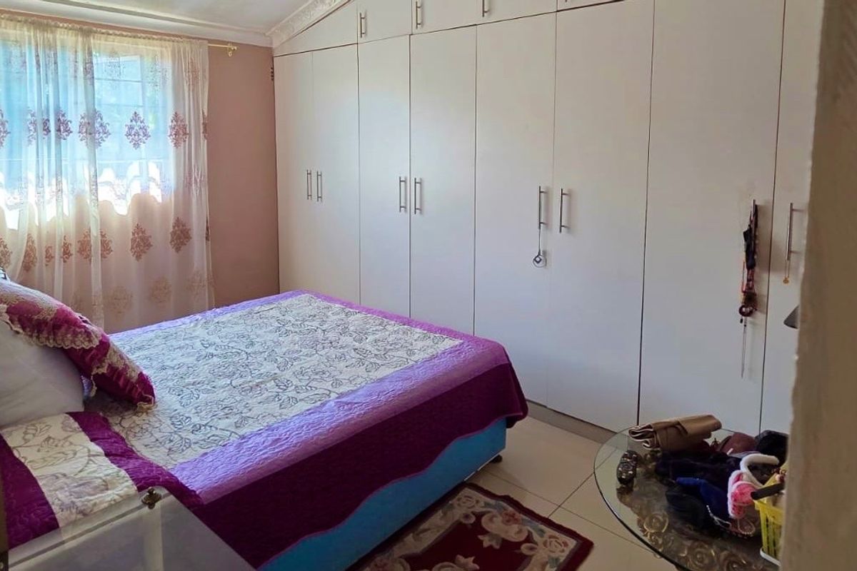 A bedroom featuring extensive floor-to-ceiling built-in cupboards providing ample storage space.