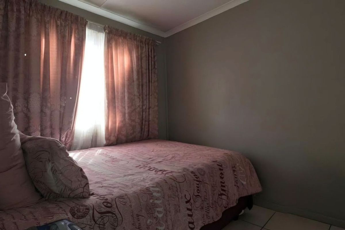 A standard bedroom featuring tiled flooring and built-in cupboard storage.