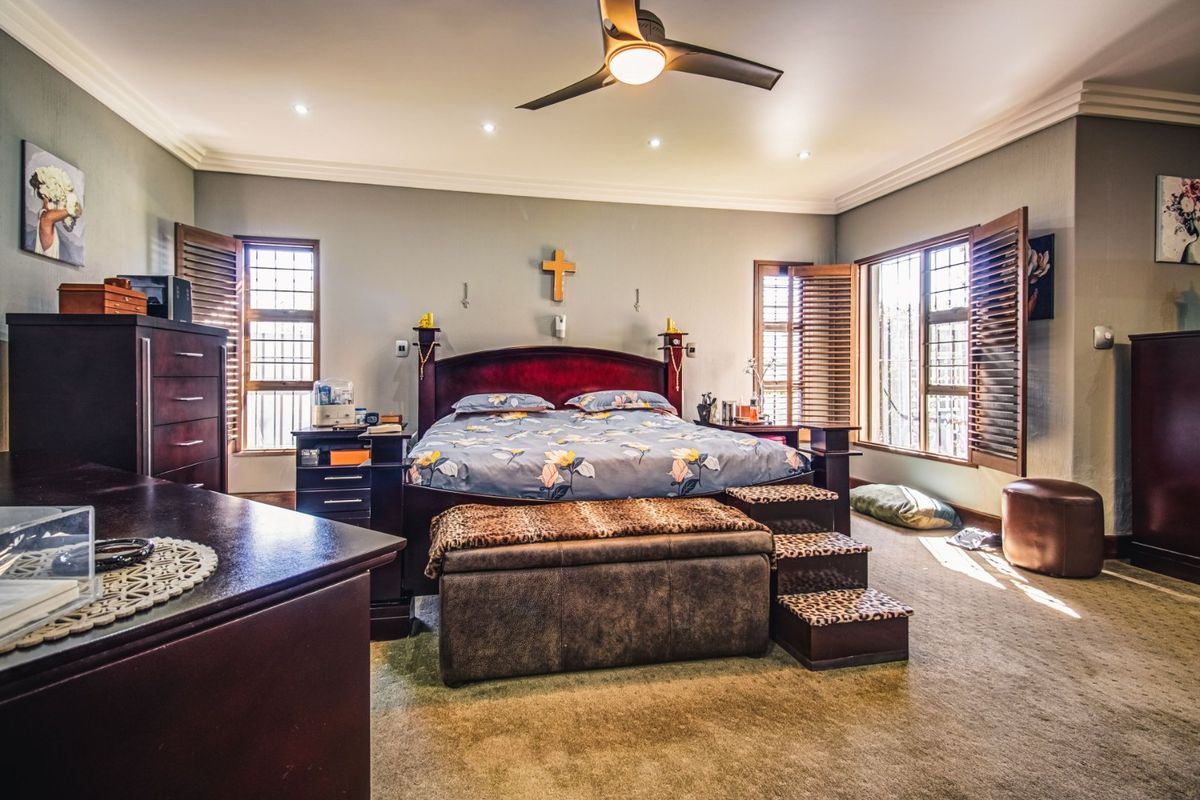 Spacious bedroom featuring recessed lighting, a ceiling fan, and wooden shutters with security bars on the windows.