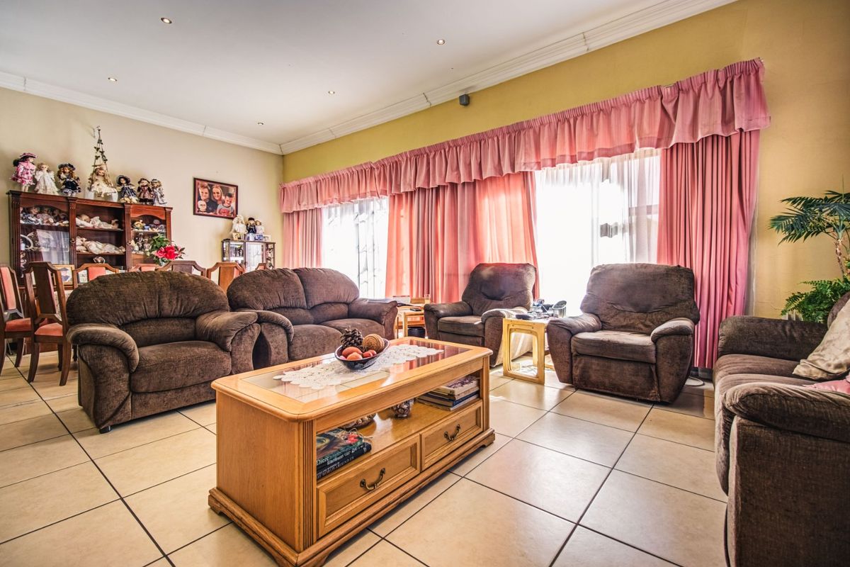 Spacious living room featuring ceramic floor tiles, recessed downlighting, and large sliding glass doors providing access to the exterior.