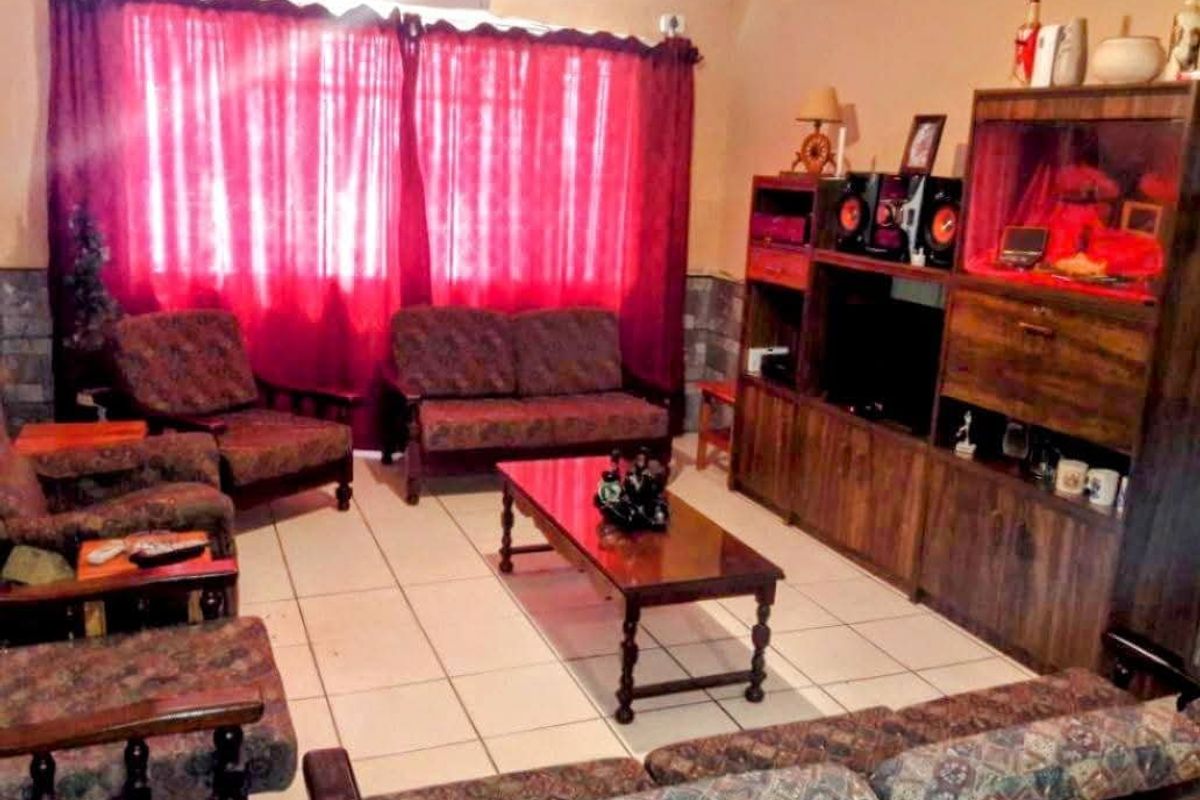 A living room featuring tiled flooring and coving, providing a functional space for relaxation.