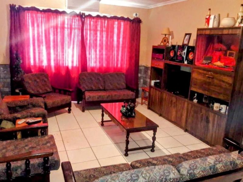 A living room featuring tiled flooring and coving, providing a functional space for relaxation.