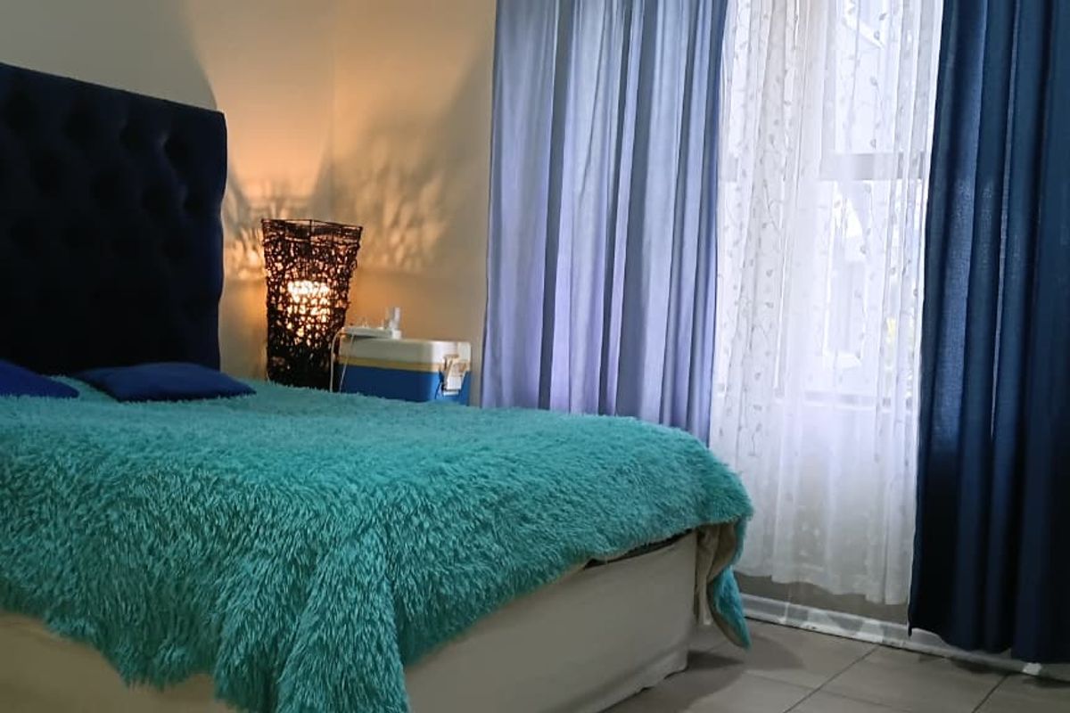 A bedroom featuring tiled flooring and a built-in wardrobe, offering a functional space with neutral wall finishes.