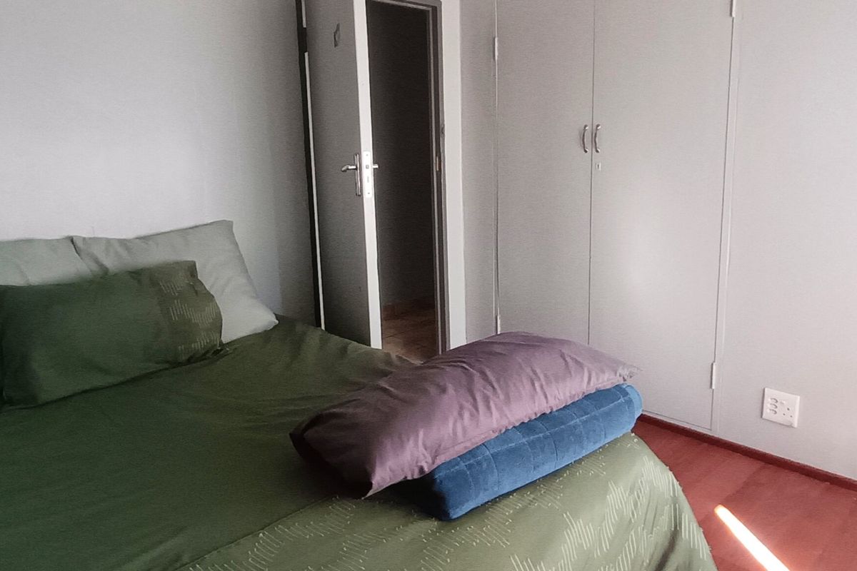 A bedroom featuring laminate flooring and built-in cupboards, providing functional storage space.