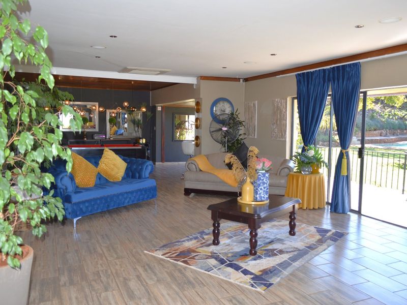 Spacious living area featuring tiled flooring, recessed lighting, and large sliding glass doors providing access to the outdoor pool area.