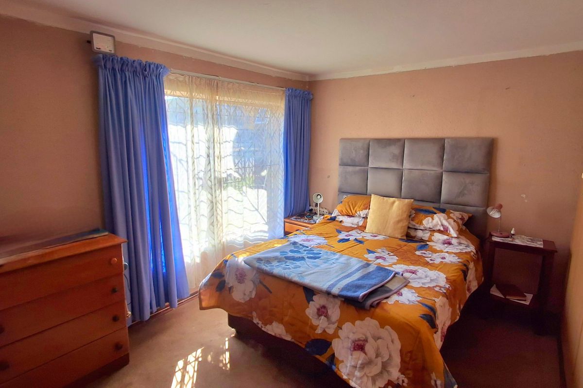A bedroom featuring a built-in wardrobe, carpeted flooring, and a sliding glass door providing natural light.