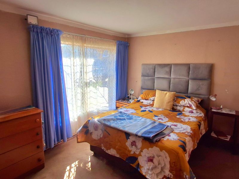A bedroom featuring a built-in wardrobe, carpeted flooring, and a sliding glass door providing natural light.