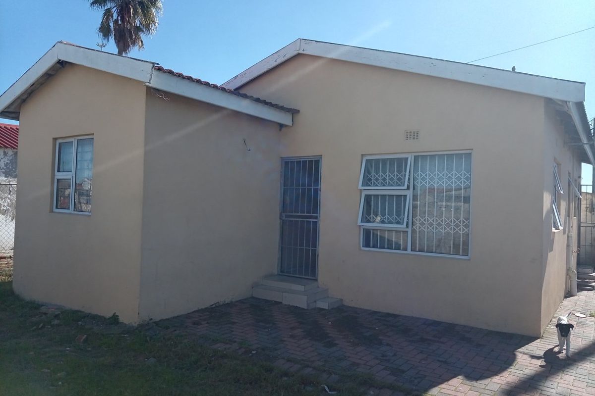 Rear view of the property featuring a paved patio area, security gates, and aluminium window frames with security bars.