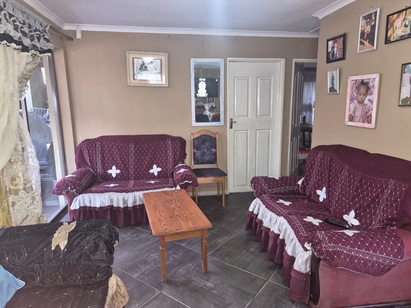 A living room featuring tiled flooring and a sliding glass door providing access to the exterior.