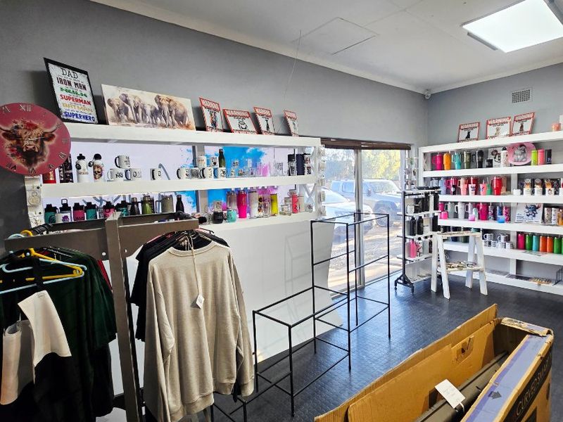 Commercial retail space featuring rubber flooring, recessed lighting, and large sliding glass doors, currently utilized for merchandise display.