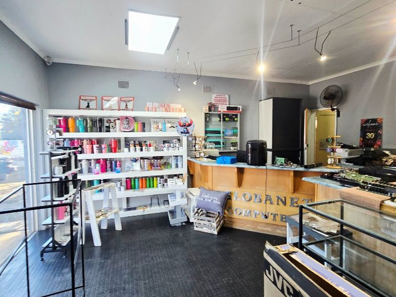 A commercial retail space featuring a built-in service counter, durable rubber flooring, and recessed ceiling lighting with a skylight.