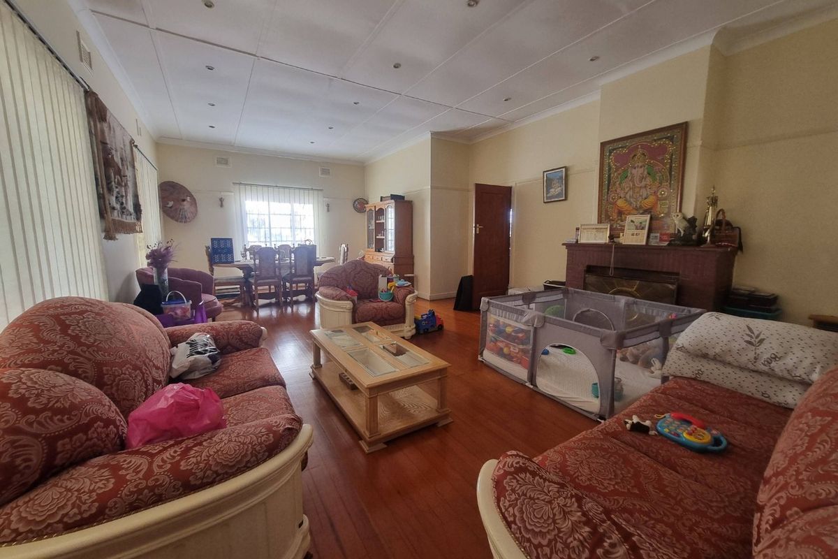 Spacious living room featuring hardwood flooring, a central fireplace, and recessed lighting, offering a comfortable and functional layout for family living.