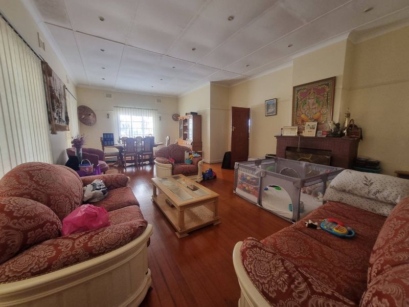 Spacious living room featuring hardwood flooring, a central fireplace, and recessed lighting, offering a comfortable and functional layout for family living.