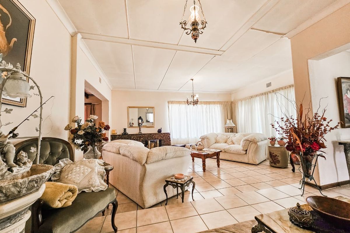 Spacious living room featuring tiled flooring, coved ceilings, and a built-in fireplace, offering a bright and open layout.