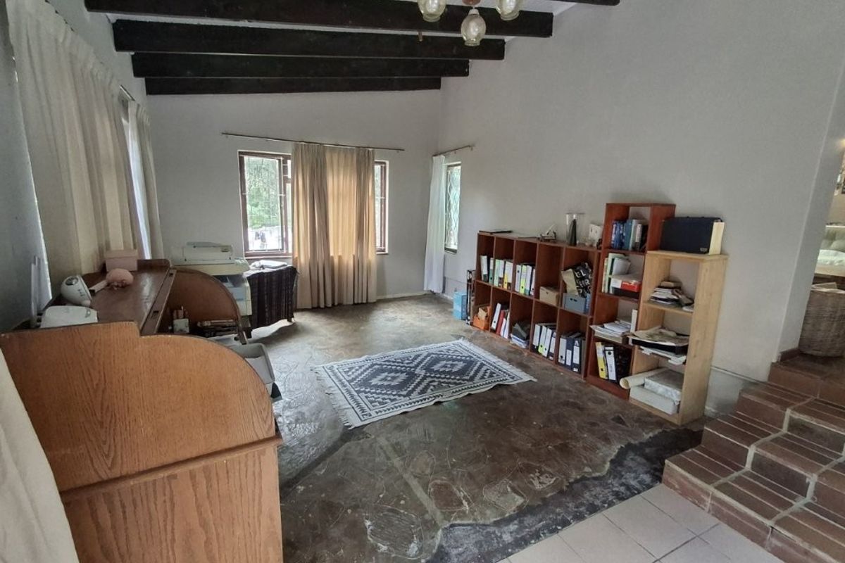 Living area featuring exposed timber ceiling beams and stone flooring, offering a rustic aesthetic with potential for modernization.