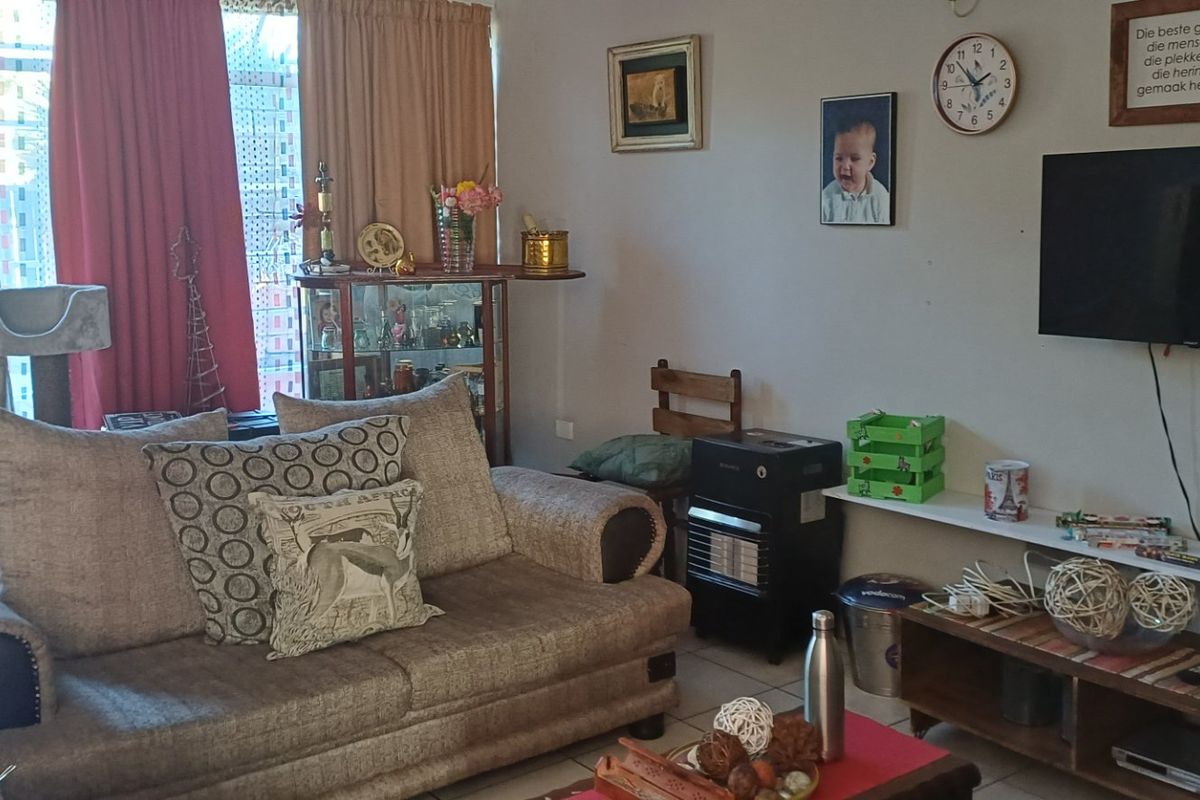 A living room area featuring tiled flooring and a sliding door providing access to the outdoor space.
