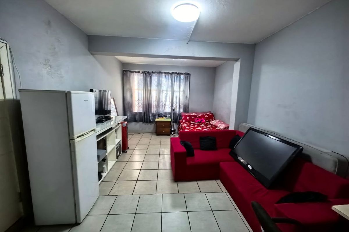 Open-plan living and sleeping area featuring tiled flooring and a functional layout suitable for compact apartment living.