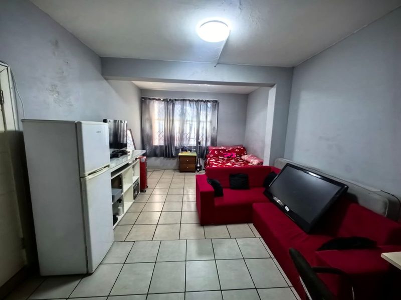 Open-plan living and sleeping area featuring tiled flooring and a functional layout suitable for compact apartment living.