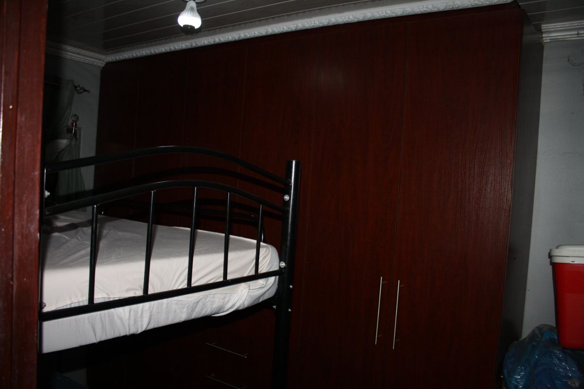A bedroom featuring dark wood built-in cabinetry and crown molding.