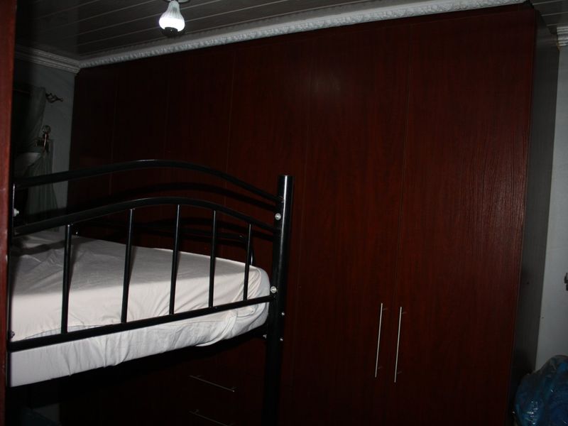 A bedroom featuring dark wood built-in cabinetry and crown molding.