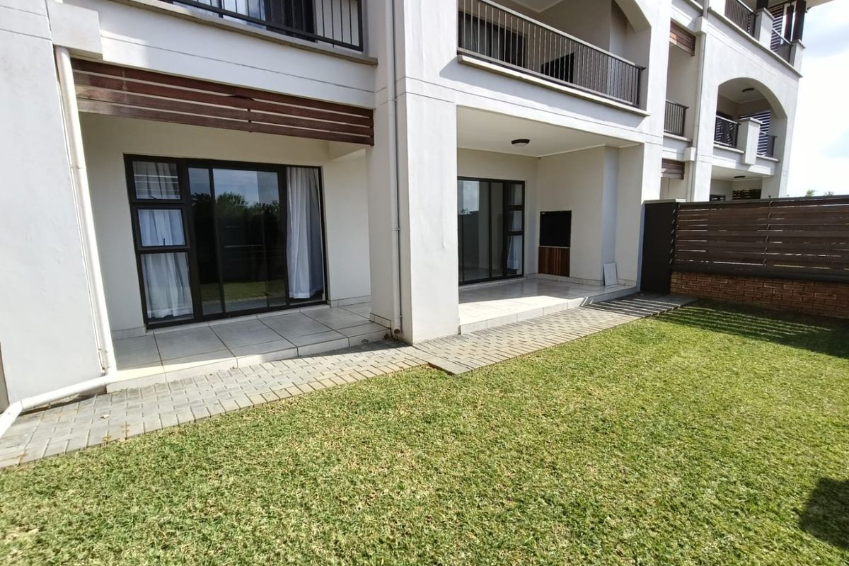 Ground floor apartment featuring a covered patio with built-in braai, tiled flooring, and direct access to a private garden area.