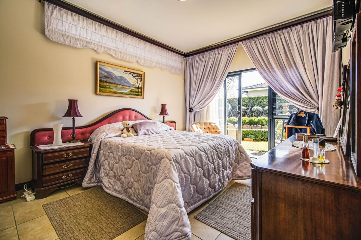 A bedroom featuring tiled flooring and a sliding glass door providing direct access to the garden area.