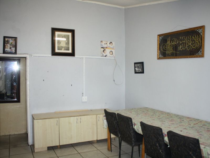 A dining area featuring tiled flooring and built-in cabinetry, requiring minor cosmetic updates to the wall finishes.