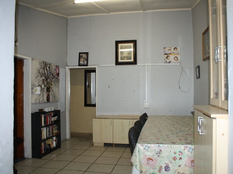Dining area featuring ceramic floor tiles and built-in cabinetry, requiring cosmetic updates to improve the overall finish and aesthetic appeal.