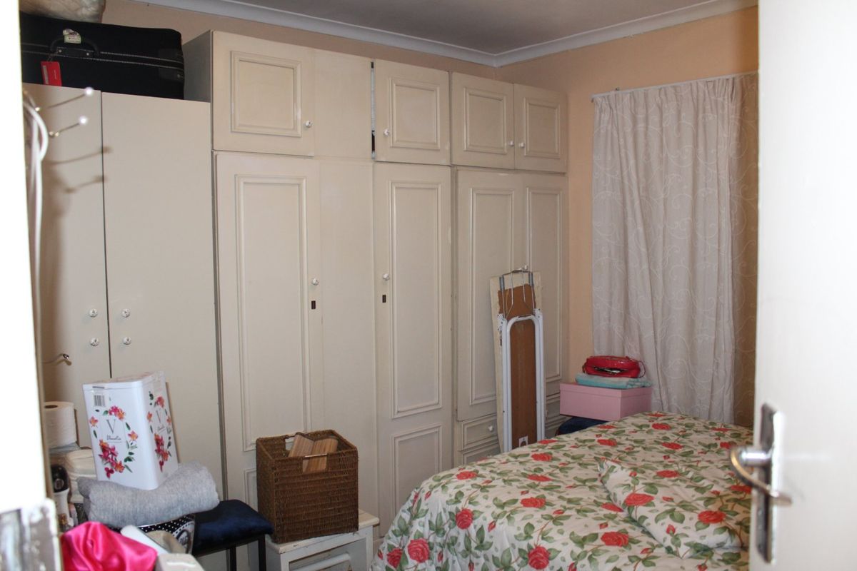 A bedroom featuring extensive built-in cabinetry and coving, providing ample storage space.