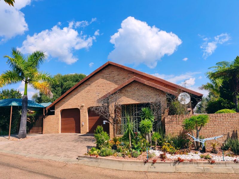A well-maintained face-brick family home featuring a double garage, paved driveway, carport, and established front garden with secure boundary walling.