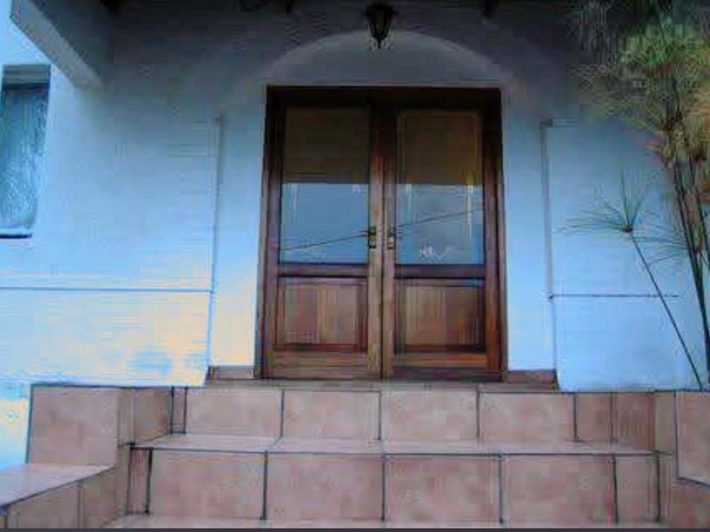 Entrance area featuring double timber doors and tiled steps leading to the main house entry.