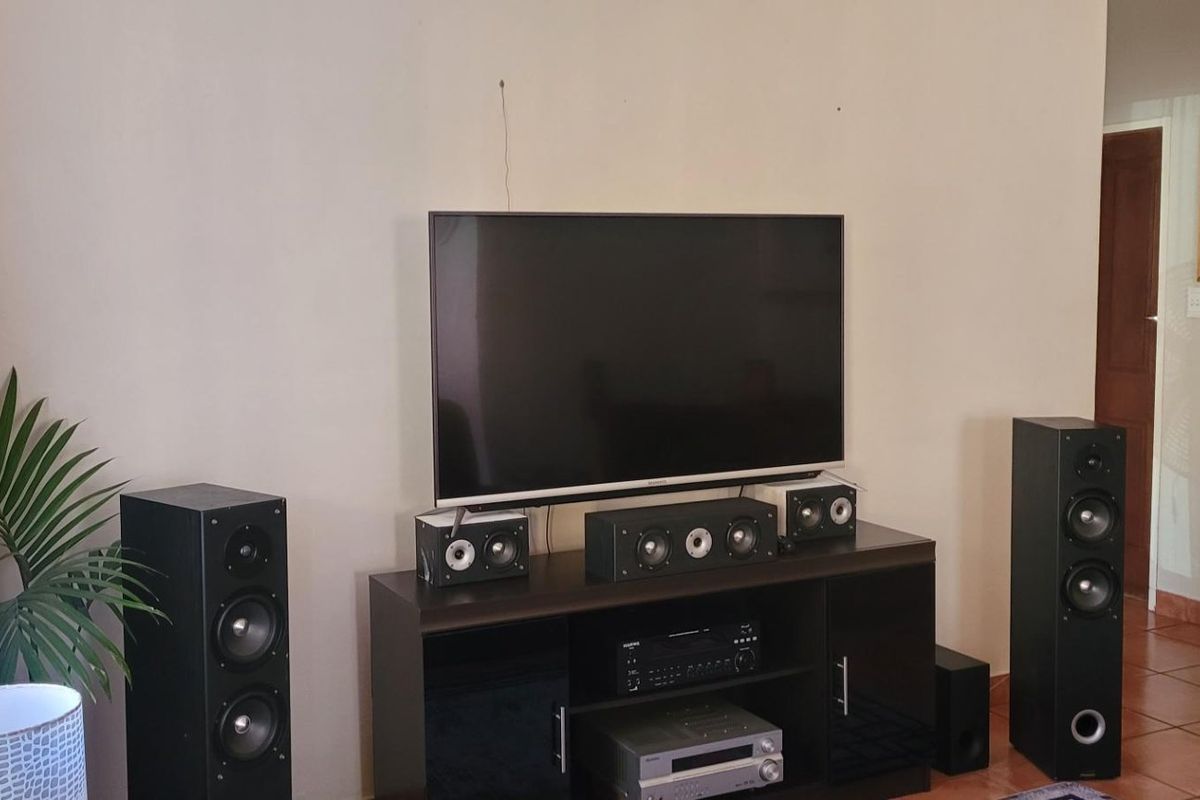 A living room area featuring tiled flooring and a neutral wall finish, providing a functional space for entertainment.