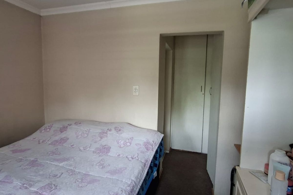 A bedroom featuring a built-in cupboard and neutral wall finishes, offering a functional space ready for cosmetic updates.